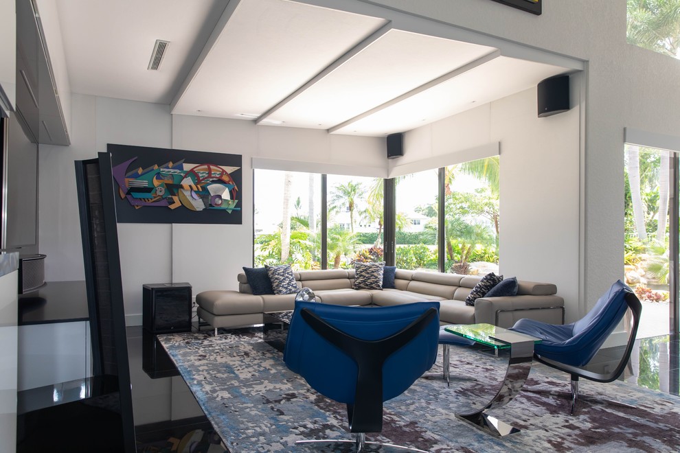 Cette image montre une grande salle de séjour minimaliste ouverte avec un bar de salon, un mur blanc, un sol en marbre, un téléviseur fixé au mur et un sol noir.