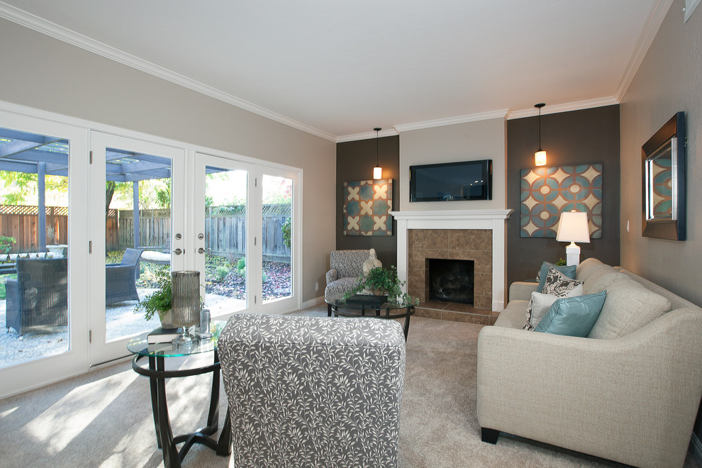 На фото: гостиная комната в современном стиле с ковровым покрытием, стандартным камином, фасадом камина из плитки, телевизором на стене и разноцветными стенами