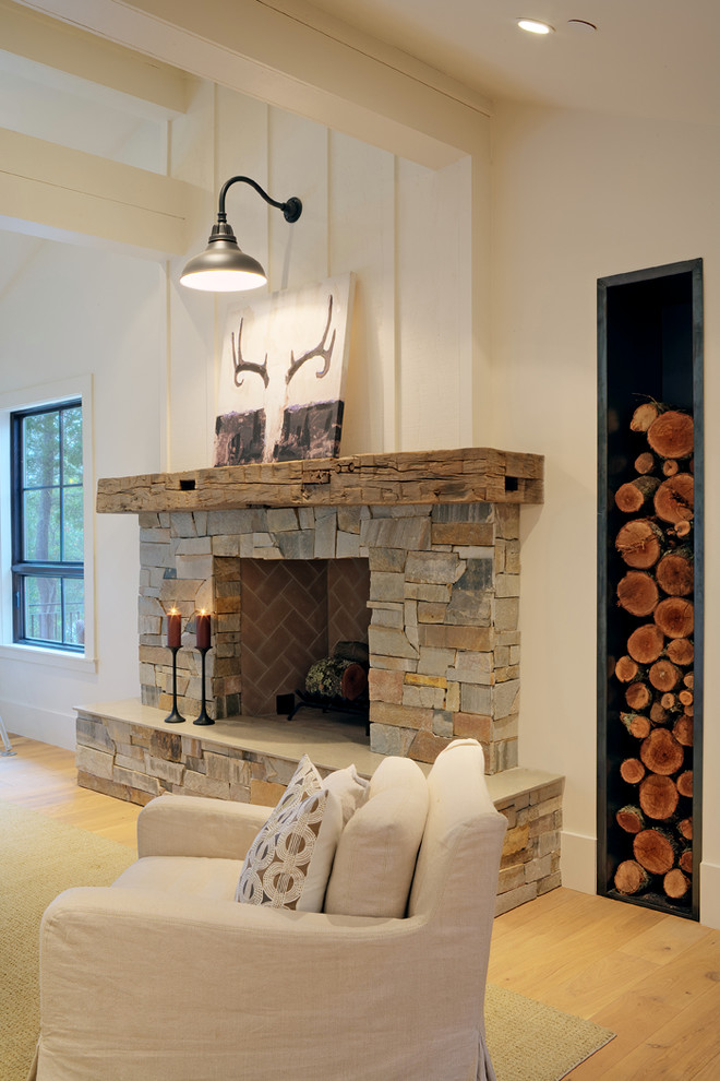 Imagen de sala de estar abierta de estilo de casa de campo de tamaño medio con todas las chimeneas, marco de chimenea de piedra, paredes blancas y suelo de madera clara