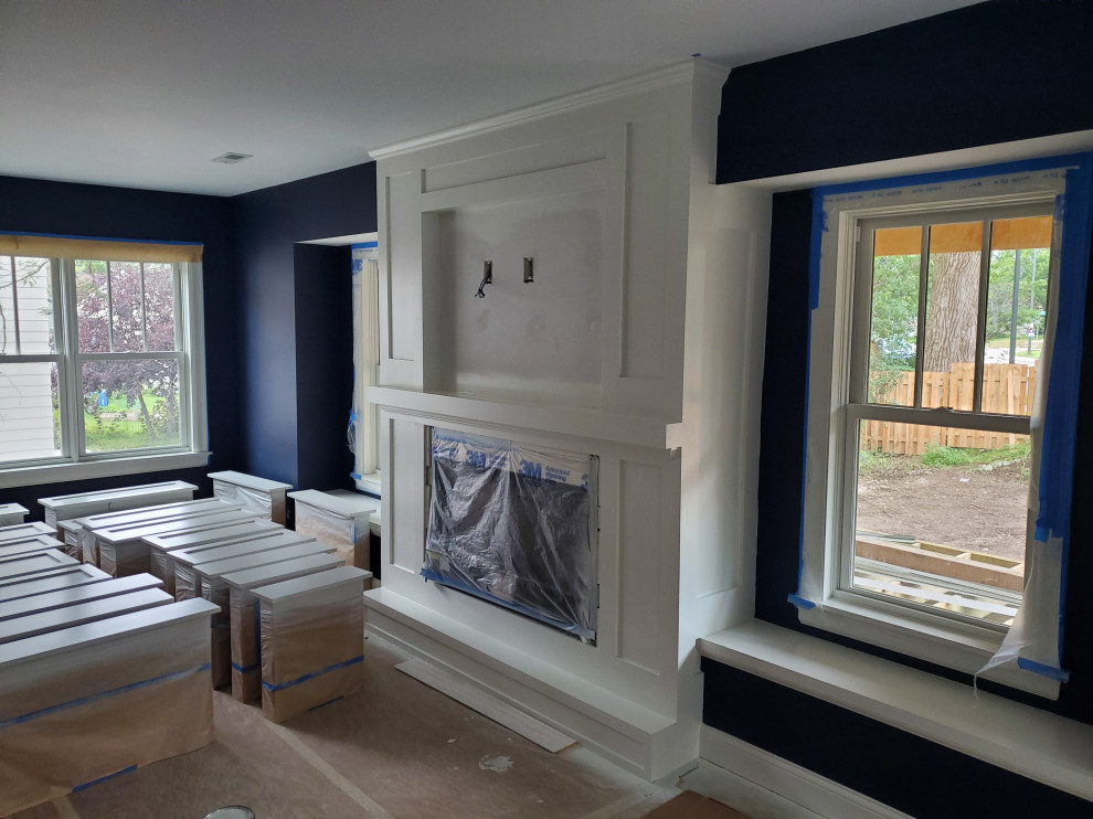 Aménagement d'une petite salle de séjour contemporaine ouverte avec un mur bleu, parquet foncé, une cheminée standard, un manteau de cheminée en béton, un téléviseur fixé au mur et un sol marron.