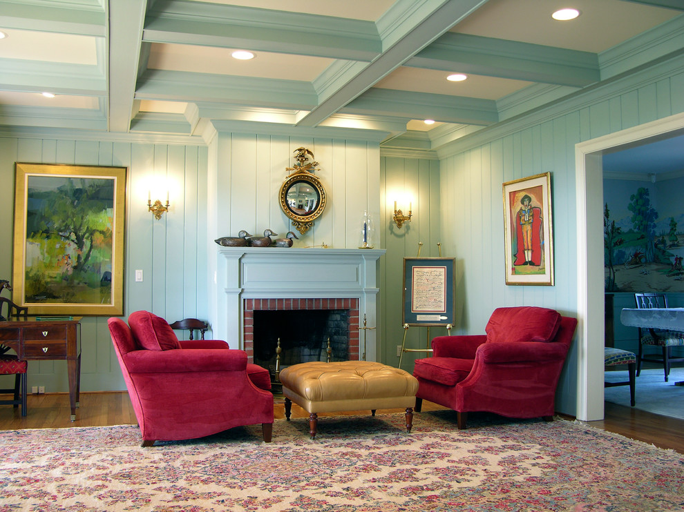 Cette image montre une grande salle de séjour traditionnelle fermée avec un mur bleu, un sol en bois brun, une cheminée standard, un manteau de cheminée en brique et un sol marron.