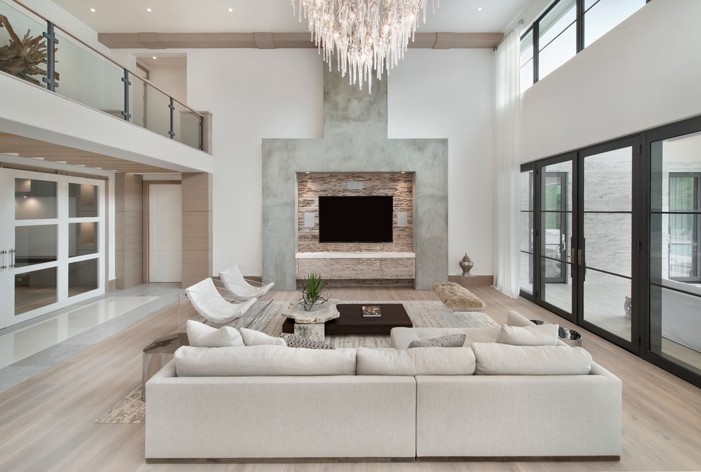 Modernes Wohnzimmer ohne Kamin mit weißer Wandfarbe, hellem Holzboden und TV-Wand in Miami
