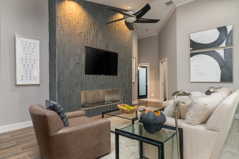 Example of a large transitional open concept laminate floor and multicolored floor family room design in Tampa with gray walls, a media wall, a ribbon fireplace and a concrete fireplace