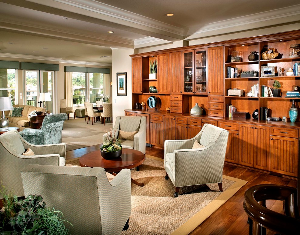 Diseño de sala de estar abierta tradicional con paredes beige, suelo de madera en tonos medios y alfombra