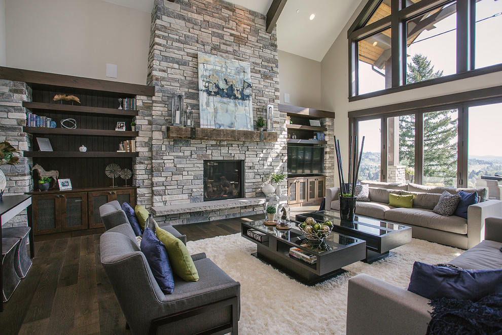 Photo of a medium sized traditional open plan games room in Portland with beige walls, dark hardwood flooring, a standard fireplace, a stacked stone fireplace surround, a freestanding tv and brown floors.