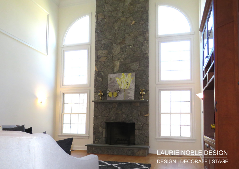 Offenes Klassisches Wohnzimmer mit weißer Wandfarbe, braunem Holzboden, Kamin, Kaminumrandung aus Stein und Multimediawand in New York