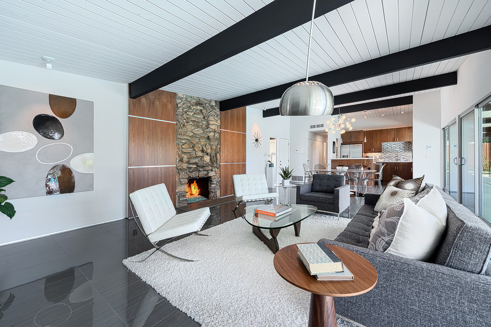 Diseño de sala de estar abierta actual sin televisor con paredes blancas, todas las chimeneas y marco de chimenea de piedra