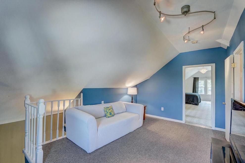 Esempio di un soggiorno american style stile loft con pareti blu, moquette, nessun camino, pavimento marrone e TV autoportante
