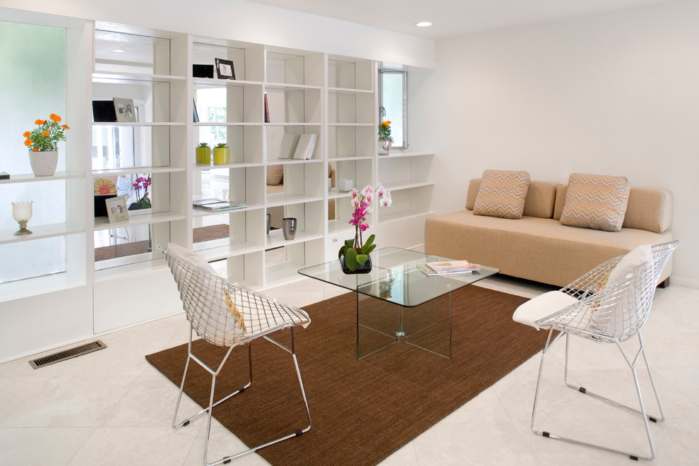 Imagen de sala de estar con biblioteca abierta actual de tamaño medio con televisor colgado en la pared, paredes blancas y suelo de piedra caliza