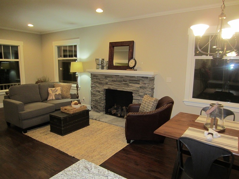 Example of a small arts and crafts dark wood floor family room design in Seattle with beige walls and a standard fireplace