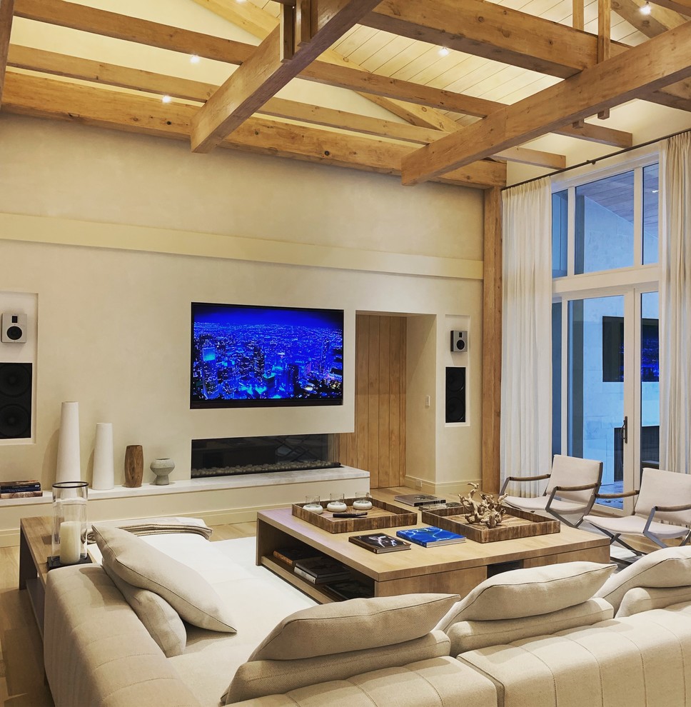 Diseño de sala de estar marinera con paredes beige, chimenea lineal y televisor colgado en la pared