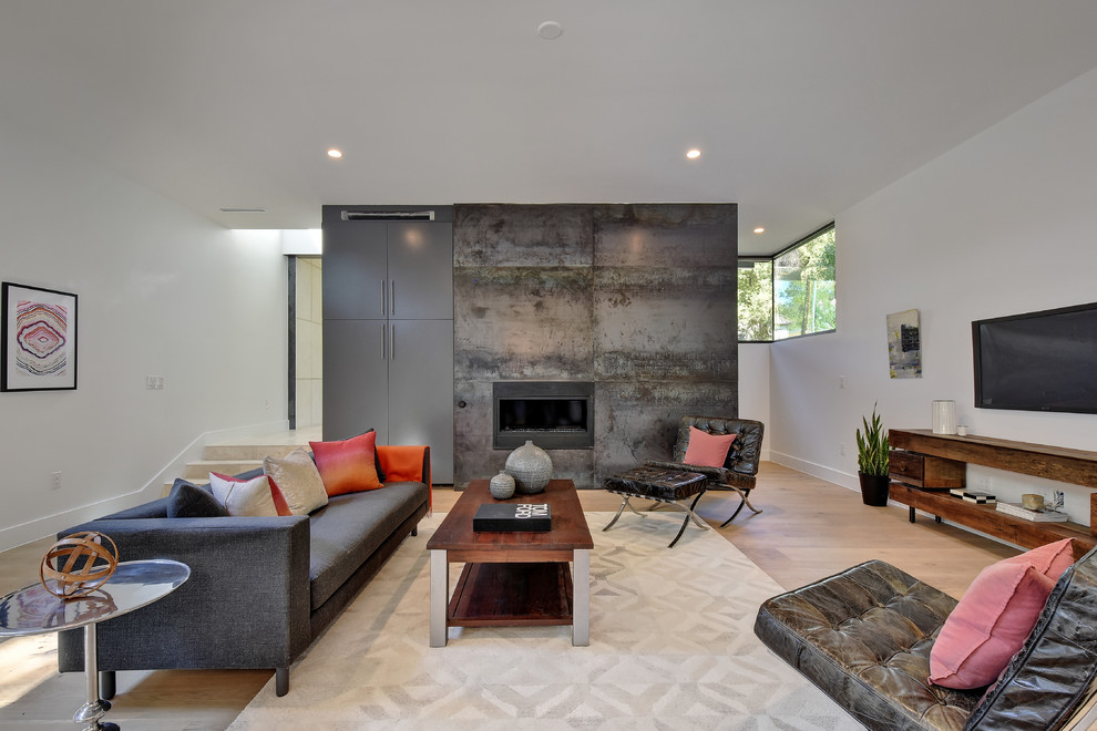 Foto de sala de estar actual con paredes blancas, suelo de madera clara, chimenea lineal y televisor colgado en la pared