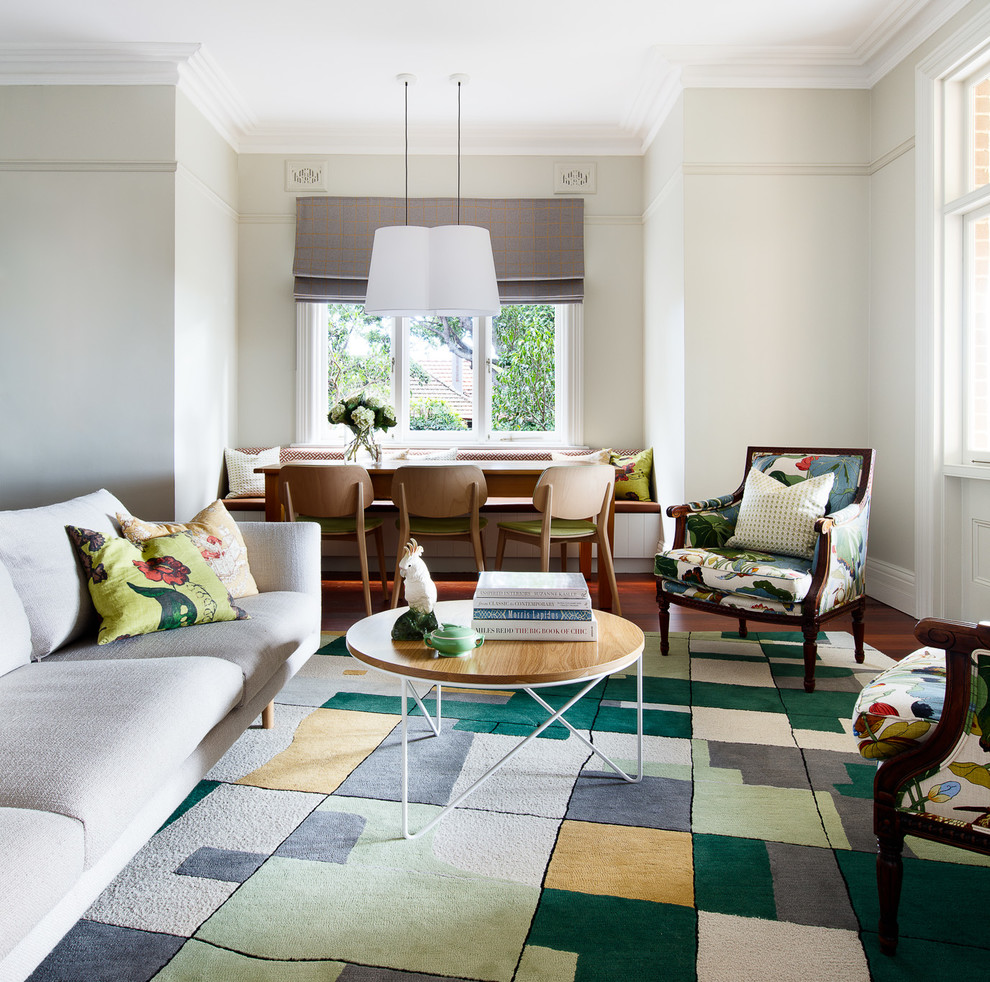 Imagen de sala de estar bohemia con paredes verdes, suelo de madera en tonos medios, televisor colgado en la pared y suelo marrón
