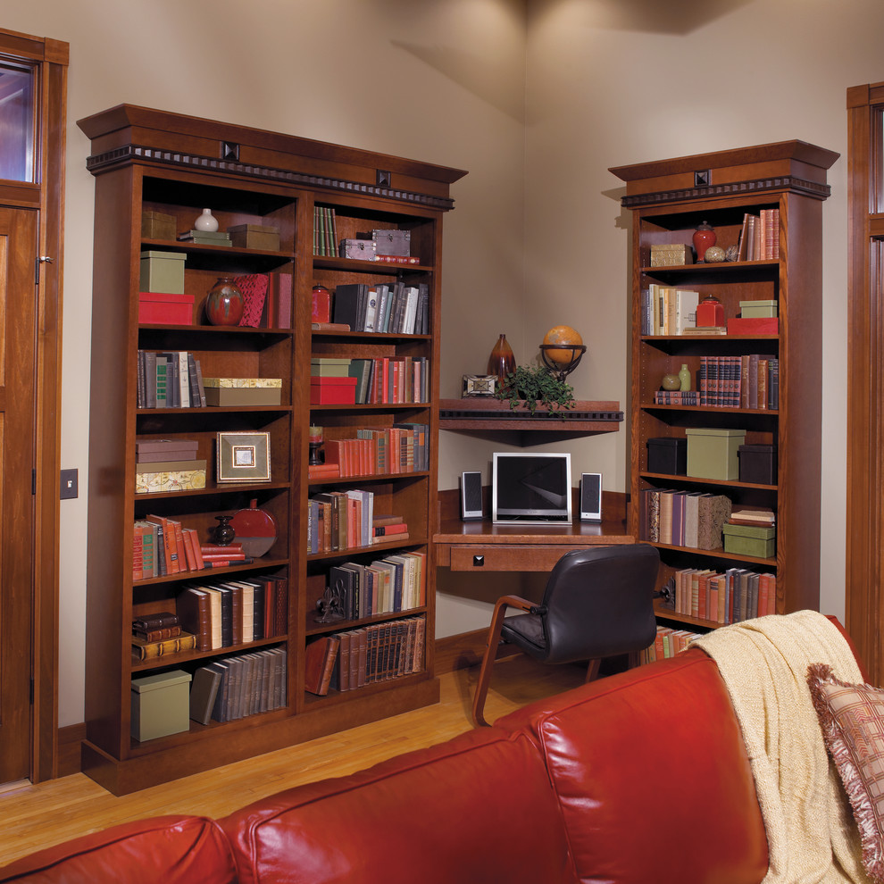 Foto de sala de estar con biblioteca cerrada actual grande con suelo de madera clara y paredes beige