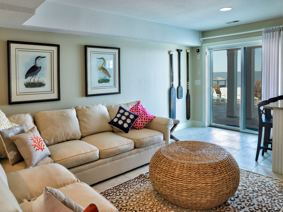 Ejemplo de sala de estar abierta costera grande sin chimenea con paredes amarillas y suelo de baldosas de cerámica
