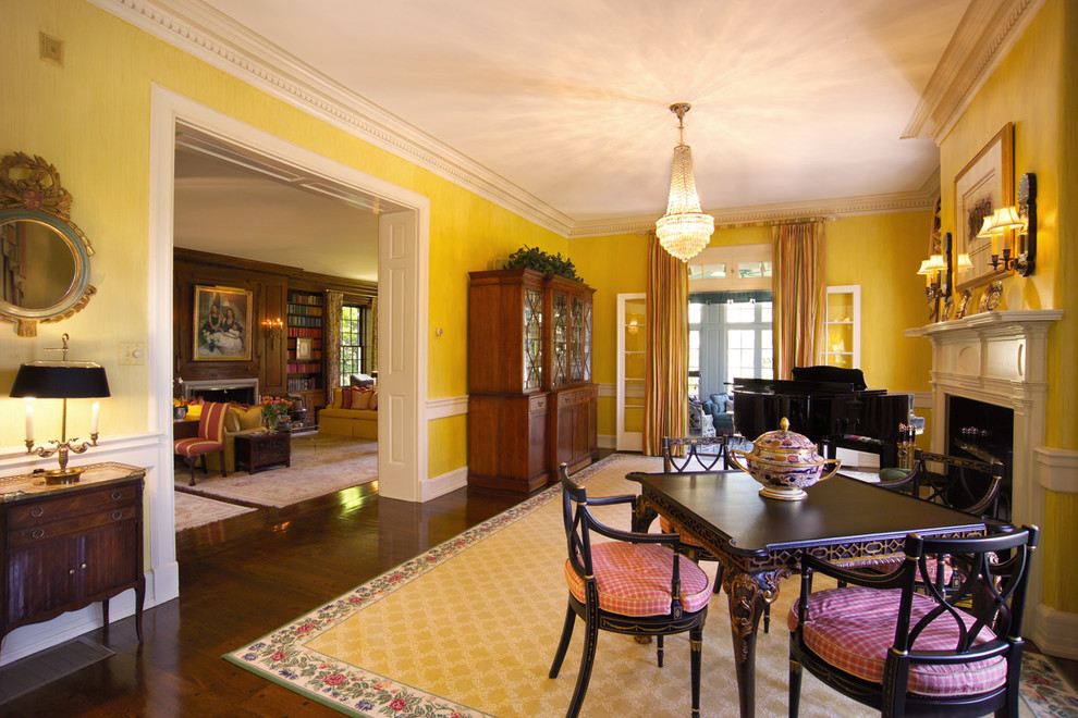 Esempio di un soggiorno tradizionale con sala della musica, pareti gialle, parquet scuro, camino classico e cornice del camino in legno