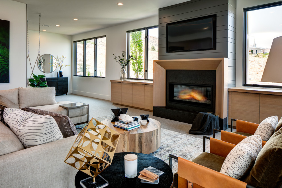 Inspiration for a large contemporary open concept carpeted and gray floor game room remodel in Salt Lake City with white walls, a standard fireplace, a wood fireplace surround and a wall-mounted tv