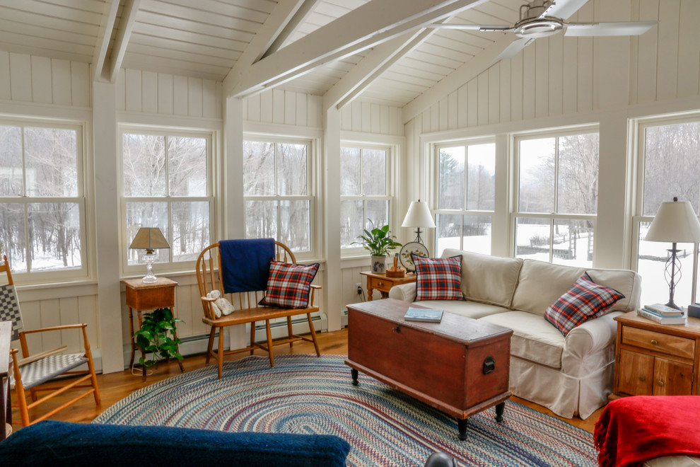 Inspiration for a mid-sized farmhouse enclosed medium tone wood floor family room remodel in Boston with white walls