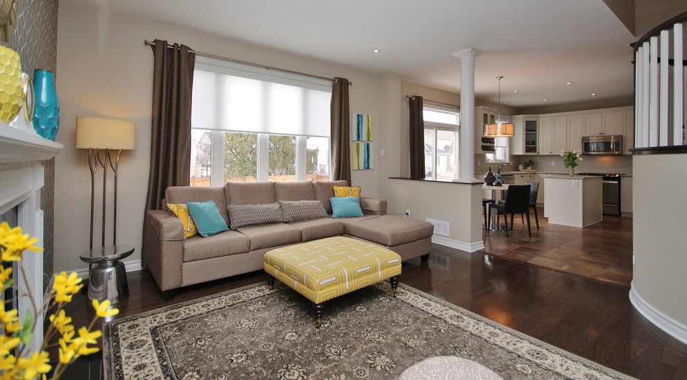 Klassisches Wohnzimmer mit beiger Wandfarbe, braunem Holzboden und Kamin in Ottawa