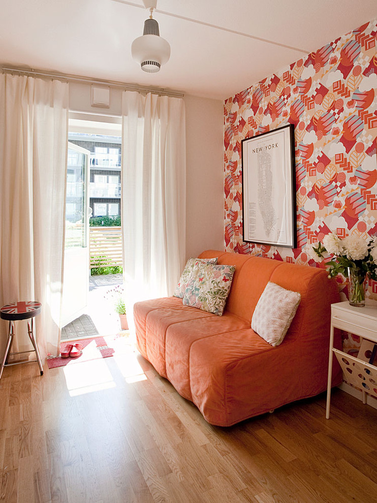 This is an example of a small contemporary open plan games room in Stockholm with medium hardwood flooring, no fireplace, no tv and multi-coloured walls.