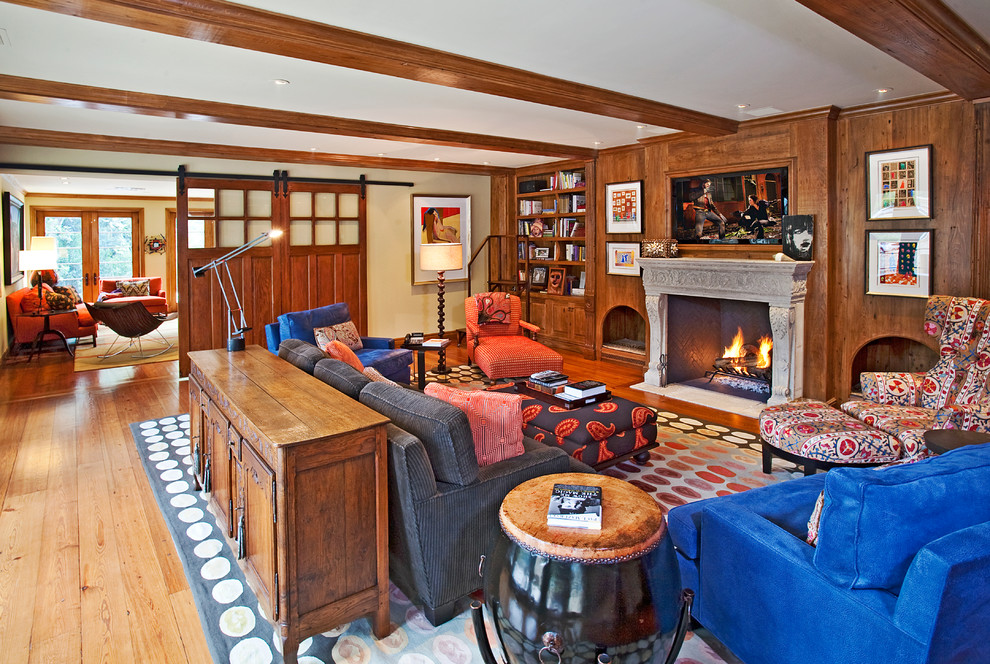 Imagen de sala de estar tradicional renovada con paredes beige, suelo de madera en tonos medios, todas las chimeneas y televisor colgado en la pared
