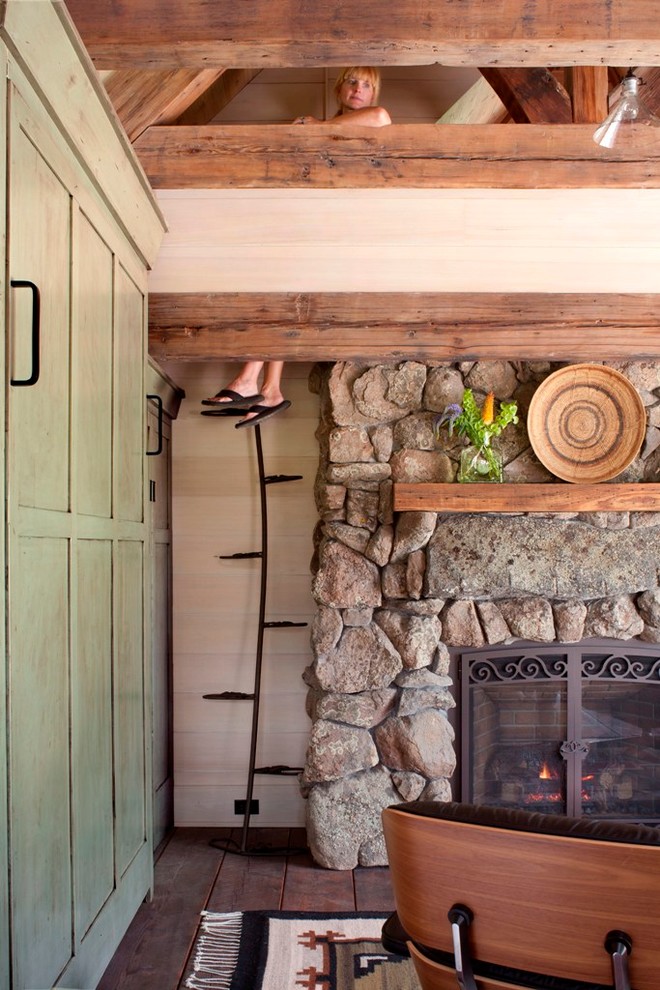 Kleines, Offenes Uriges Wohnzimmer mit braunem Holzboden, Kamin und Kaminumrandung aus Stein in Denver