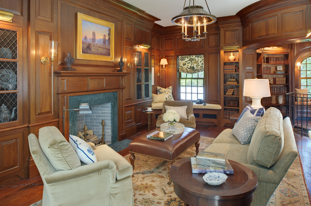 Diseño de sala de estar con biblioteca cerrada tradicional de tamaño medio con paredes marrones, suelo de madera en tonos medios, todas las chimeneas y marco de chimenea de piedra
