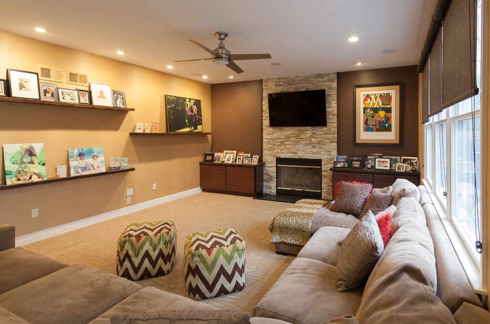 Foto de sala de juegos en casa abierta actual de tamaño medio con paredes marrones, moqueta, todas las chimeneas, marco de chimenea de piedra y televisor colgado en la pared