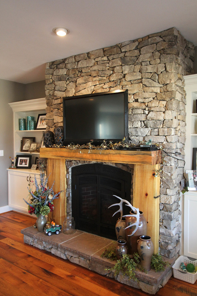 Inspiration for a medium sized rural open plan games room in DC Metro with beige walls, medium hardwood flooring, a stone fireplace surround, a wall mounted tv and a standard fireplace.