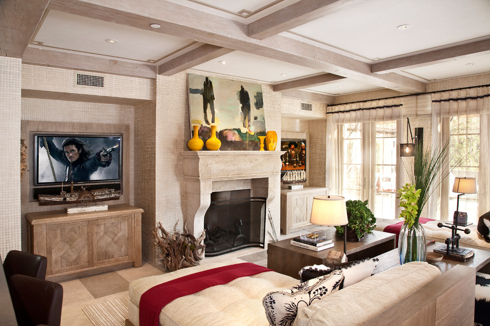 На фото: гостиная комната в средиземноморском стиле с полом из известняка, фасадом камина из камня, бежевыми стенами, стандартным камином, телевизором на стене и бежевым полом