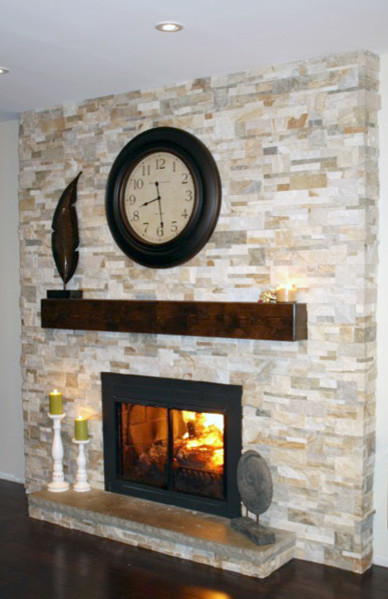 На фото: гостиная комната в стиле модернизм с стандартным камином и фасадом камина из камня без телевизора