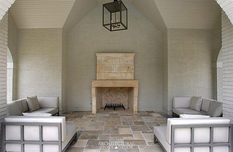 Ejemplo de sala de estar cerrada mediterránea pequeña con suelo de piedra caliza, todas las chimeneas y marco de chimenea de piedra