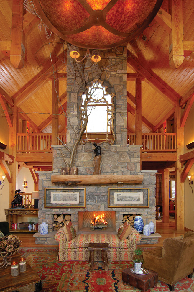 Classic open plan games room in Charlotte with beige walls, medium hardwood flooring, a standard fireplace and a stone fireplace surround.