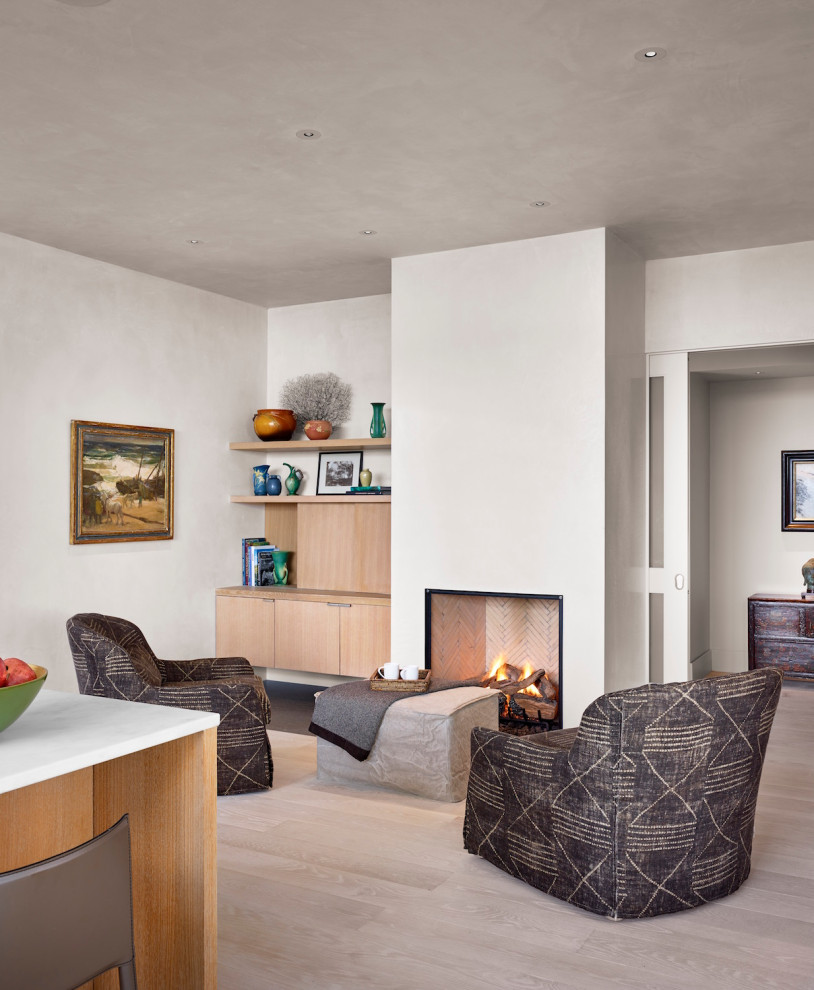 Example of a huge mid-century modern enclosed light wood floor and white floor family room design in Austin with white walls, a standard fireplace and no tv