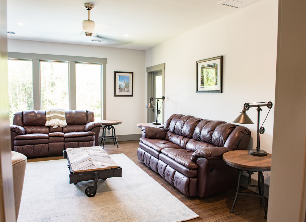 Imagen de sala de estar cerrada rural de tamaño medio sin chimenea con paredes beige, suelo de madera oscura, televisor colgado en la pared y suelo marrón