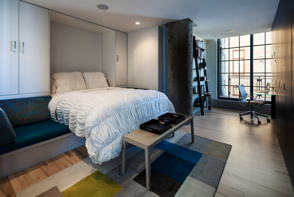 Mittelgroßes, Abgetrenntes Industrial Wohnzimmer mit grauer Wandfarbe, hellem Holzboden und verstecktem TV in Minneapolis