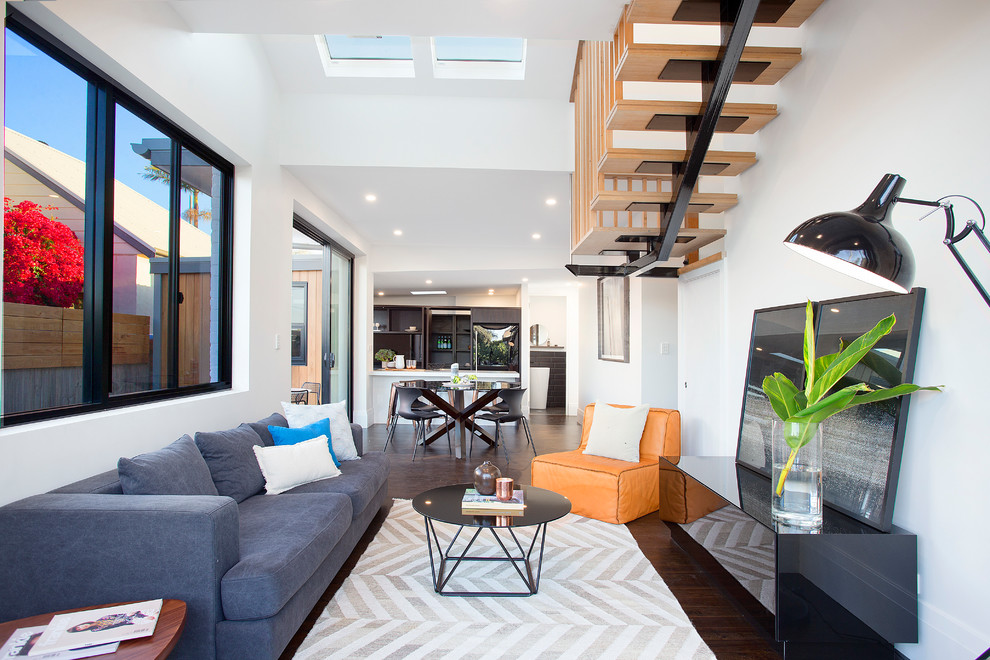 Fernseherloses, Offenes Modernes Wohnzimmer ohne Kamin mit weißer Wandfarbe, dunklem Holzboden und braunem Boden in Sydney