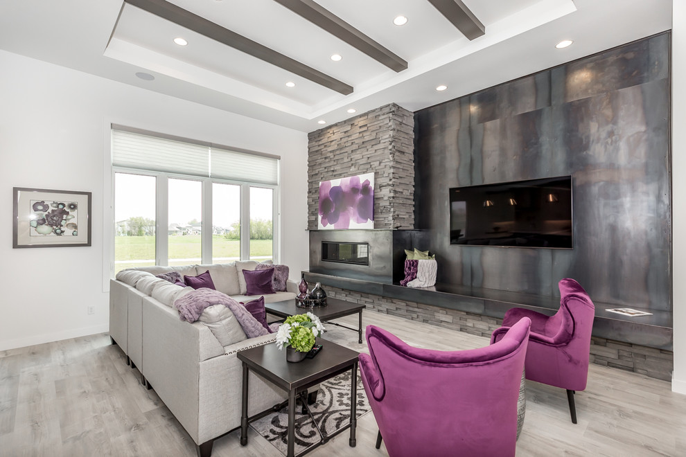 Minimalist open concept laminate floor and gray floor family room photo with gray walls, a standard fireplace, a stone fireplace and a wall-mounted tv