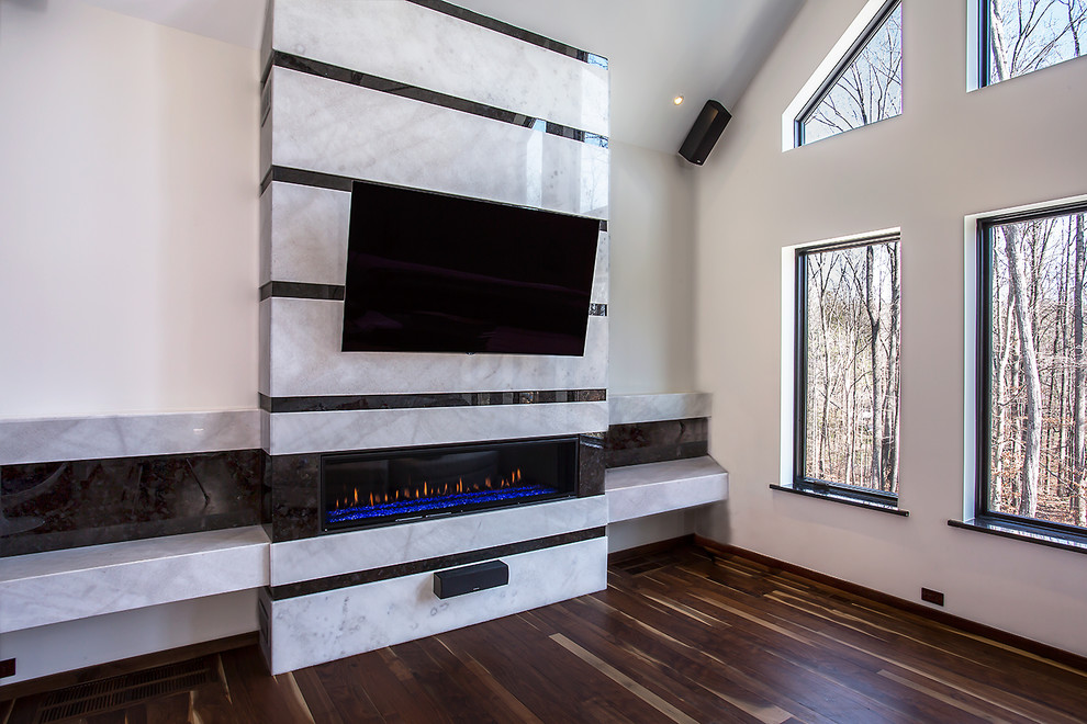 Ejemplo de sala de estar abierta moderna extra grande con chimenea lineal, marco de chimenea de piedra y televisor colgado en la pared