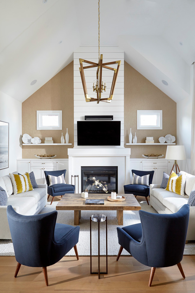 Diseño de sala de estar abierta tradicional renovada grande con suelo de madera clara, todas las chimeneas, televisor colgado en la pared, paredes beige y alfombra