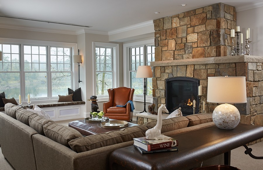 На фото: открытая гостиная комната в классическом стиле с бежевыми стенами, ковровым покрытием, стандартным камином, бежевым полом и фасадом камина из каменной кладки с