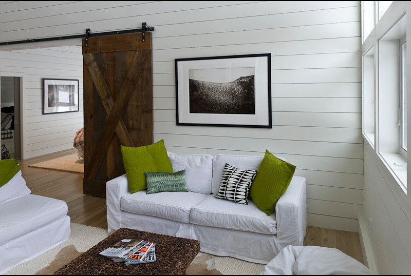 Imagen de sala de estar abierta actual de tamaño medio con paredes blancas y suelo de madera clara