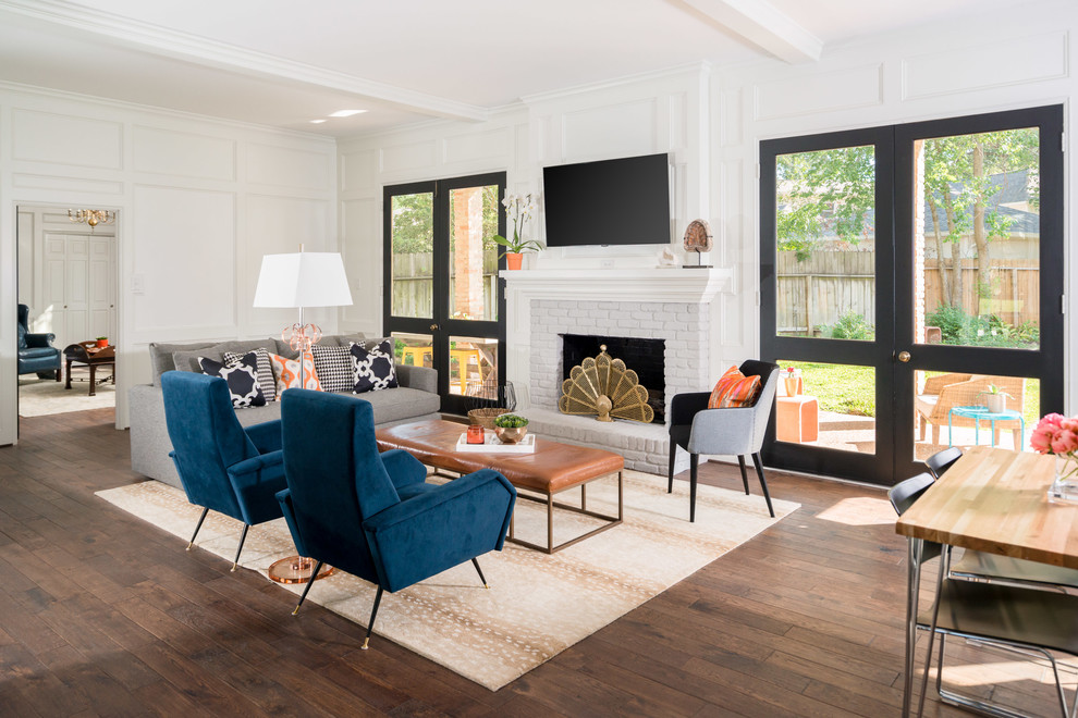 Family room - transitional dark wood floor and brown floor family room idea in Houston with white walls, a standard fireplace, a brick fireplace and a wall-mounted tv