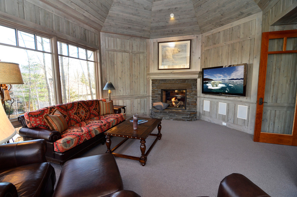 Foto de sala de estar cerrada clásica grande con paredes grises, moqueta, todas las chimeneas, marco de chimenea de piedra y televisor colgado en la pared