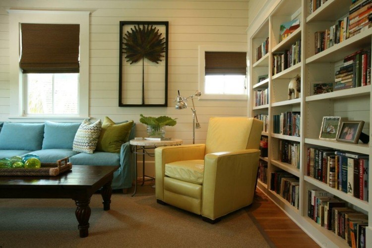 Cette photo montre une salle de séjour tendance de taille moyenne et fermée avec une bibliothèque ou un coin lecture, un mur blanc, un sol en bois brun, aucune cheminée et aucun téléviseur.