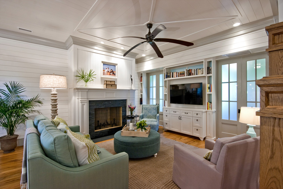 Family room - traditional medium tone wood floor family room idea in Charleston with white walls, a standard fireplace and a wall-mounted tv