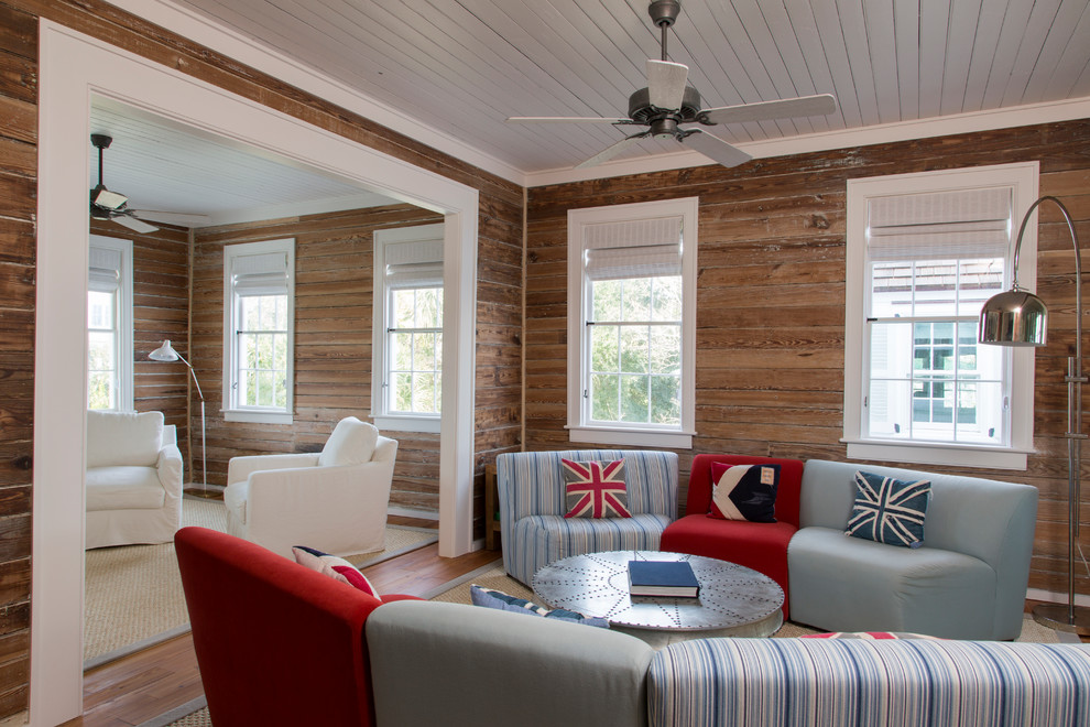 Ejemplo de sala de estar abierta costera con paredes marrones y suelo de madera en tonos medios
