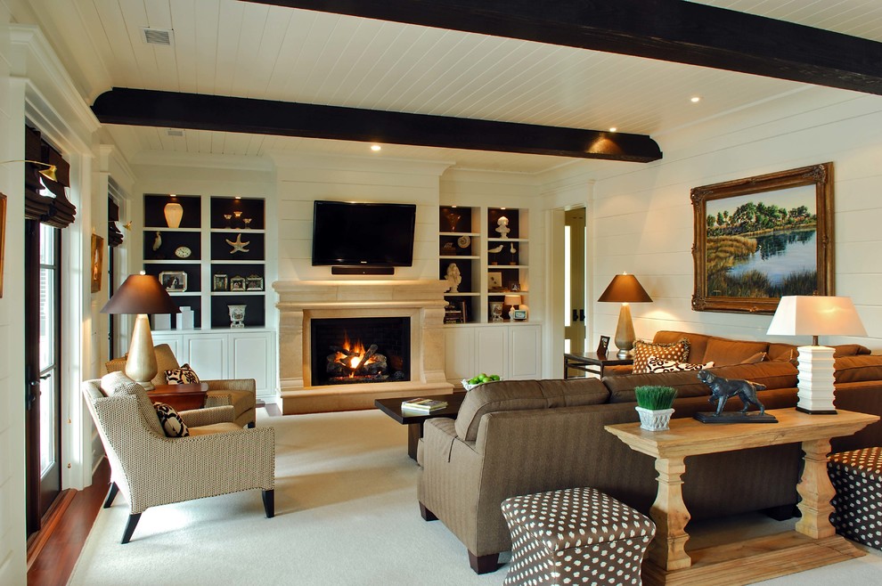 На фото: гостиная комната в классическом стиле с стандартным камином, фасадом камина из камня и телевизором на стене с