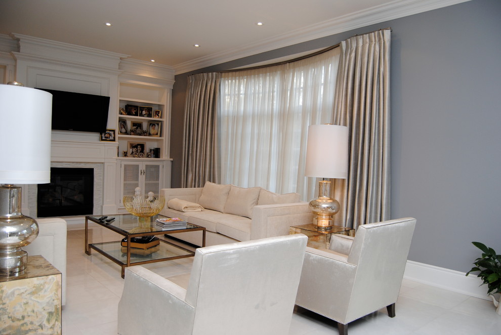 This is an example of a medium sized traditional open plan games room in Toronto with grey walls, marble flooring, a standard fireplace, a stone fireplace surround, a wall mounted tv and white floors.