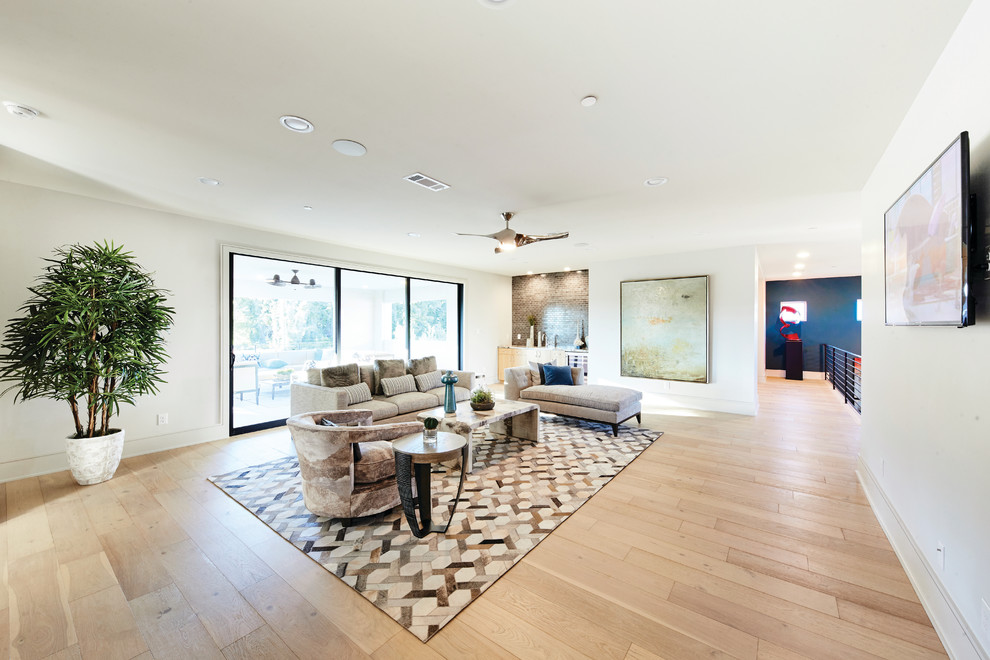 Example of a large trendy enclosed light wood floor and beige floor family room design in Dallas with a bar, white walls, no fireplace and a wall-mounted tv